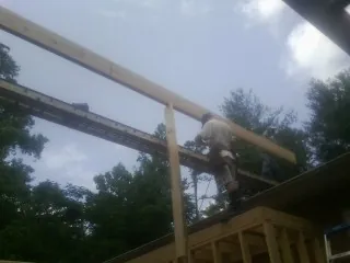Carpenter setting a ridge beam over a new addition frame — Ice Dam Removal by Roofing Brothers in Drewsville