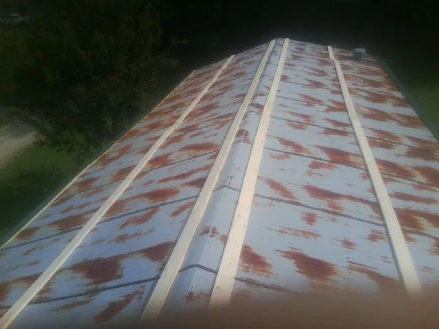 Rusted metal roof panels with new wood purlins before replacement — Storm Damage Roof Repair in Drewsville by Roofing Brothers