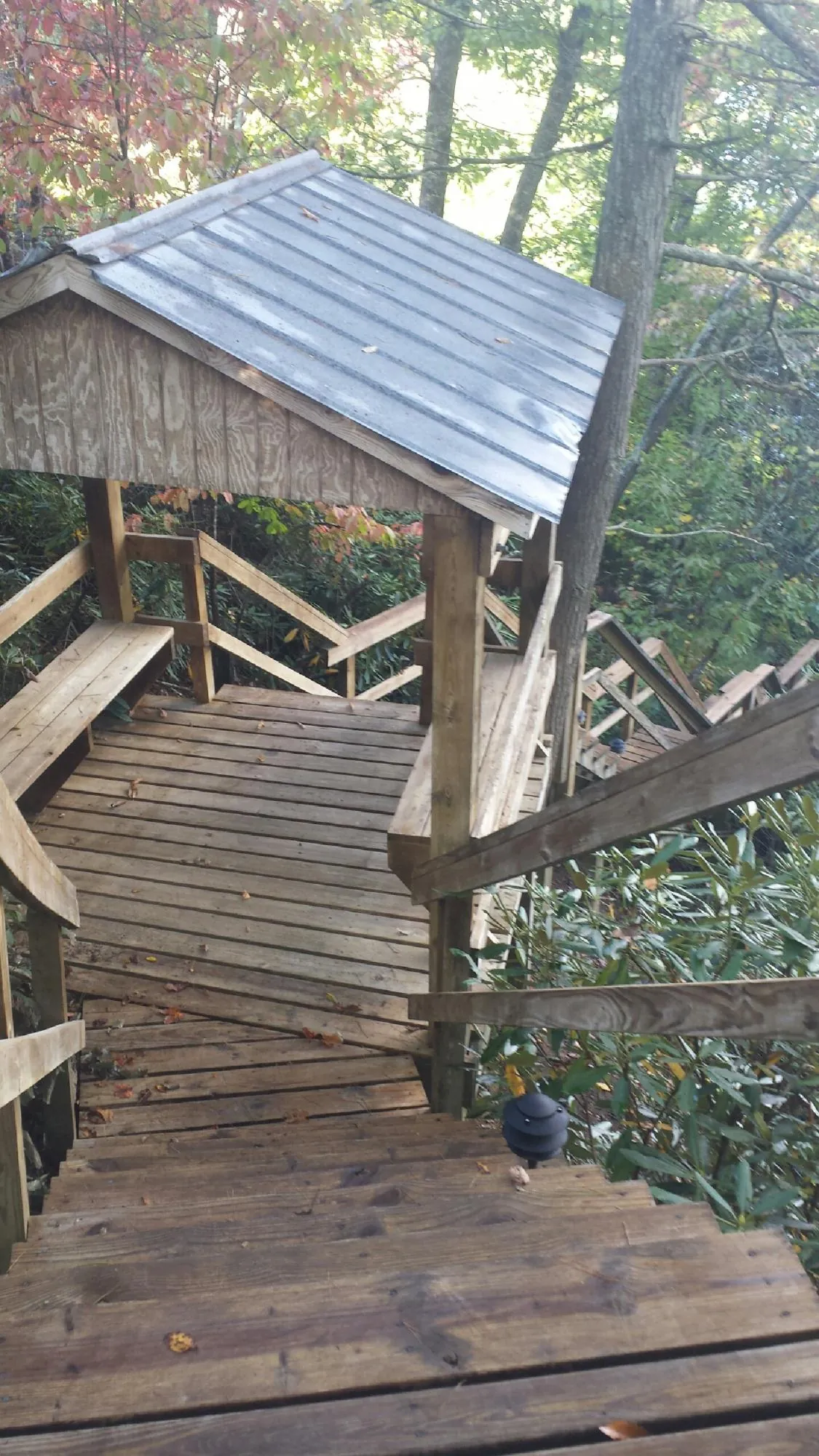 Metal roofed shelter over wooden steps on a wooded walkway — Skylight Repair & Installation work by our crew in Drewsville