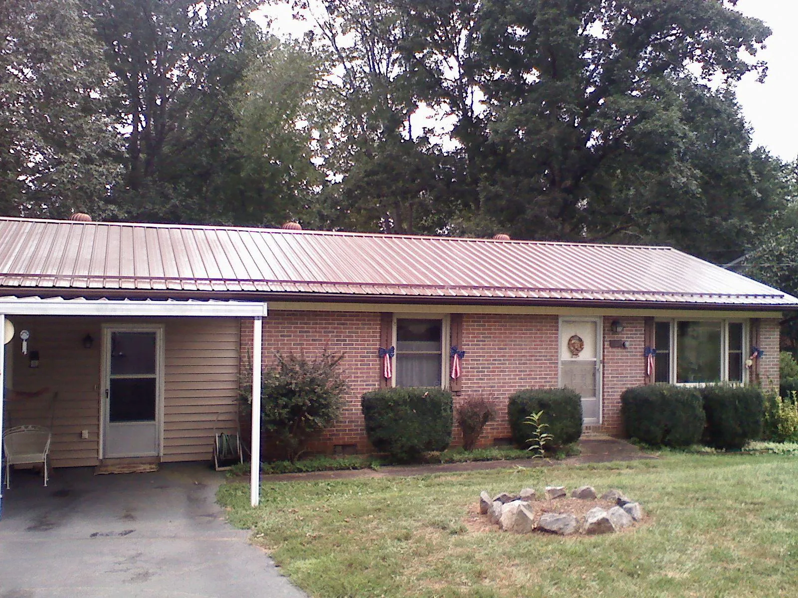 Bronze metal roof and carport on a brick ranch home — Roof Repair work by our crew in Drewsville